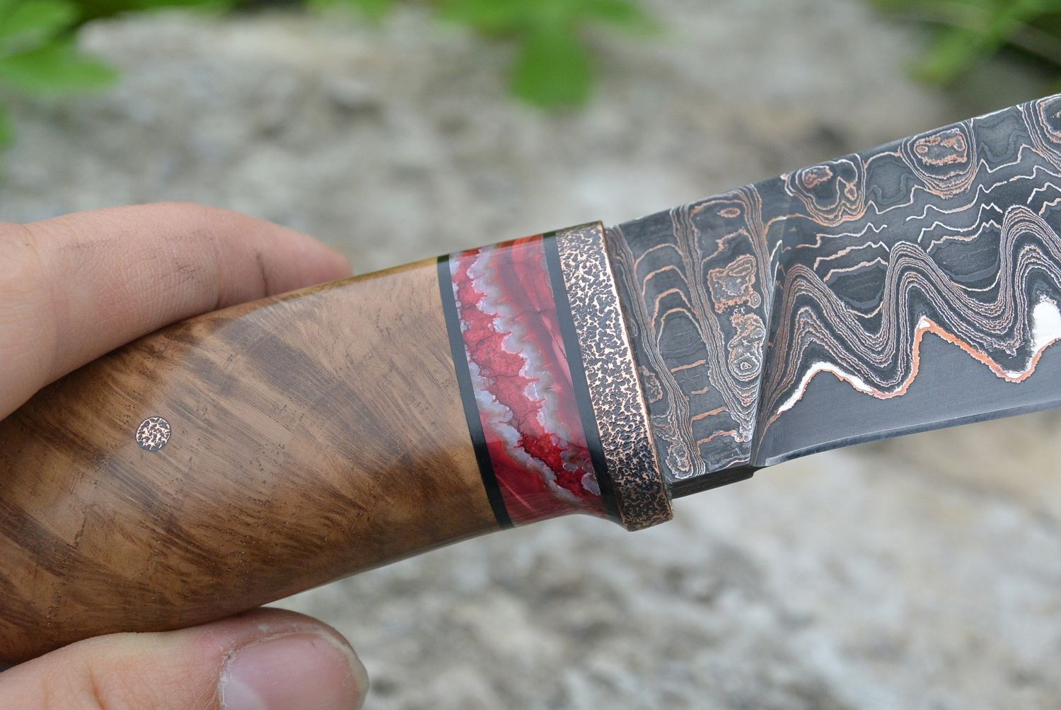 Handcrafted custom knife with a colorful stabilized mammoth tooth spacer, highlighting the natural fossil structure and unique handle construction.