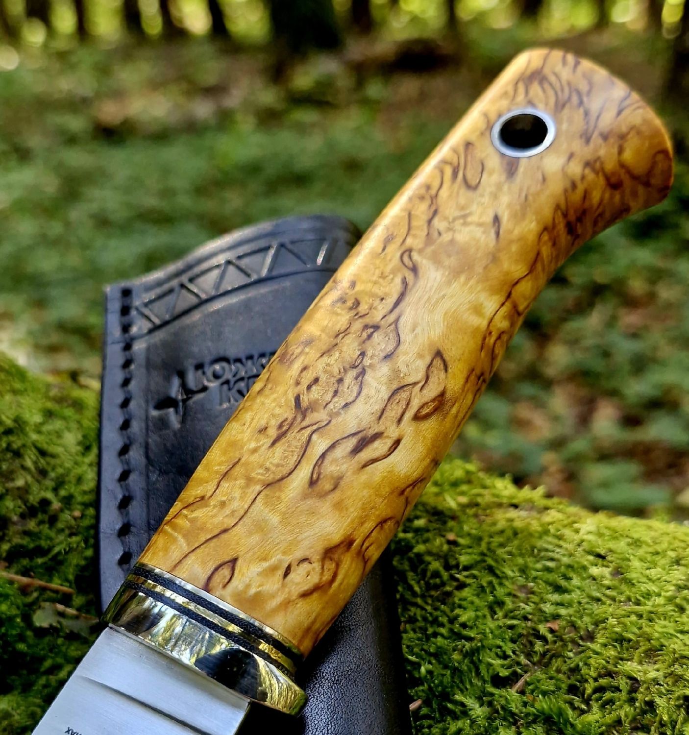 Handcrafted knife with a figured Karelian birch handle and natural swirling grain
