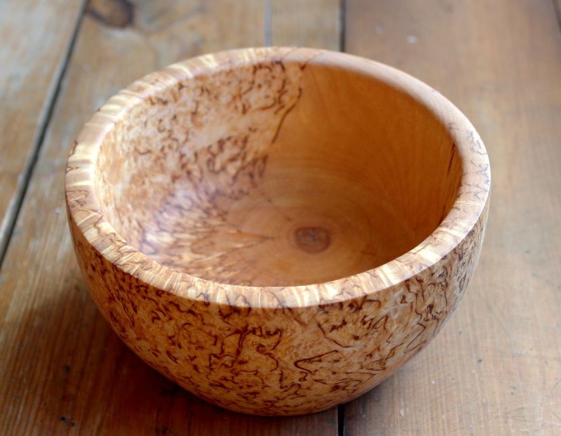 Round carved bowl made from Karelian birch wood with distinctive figured grain