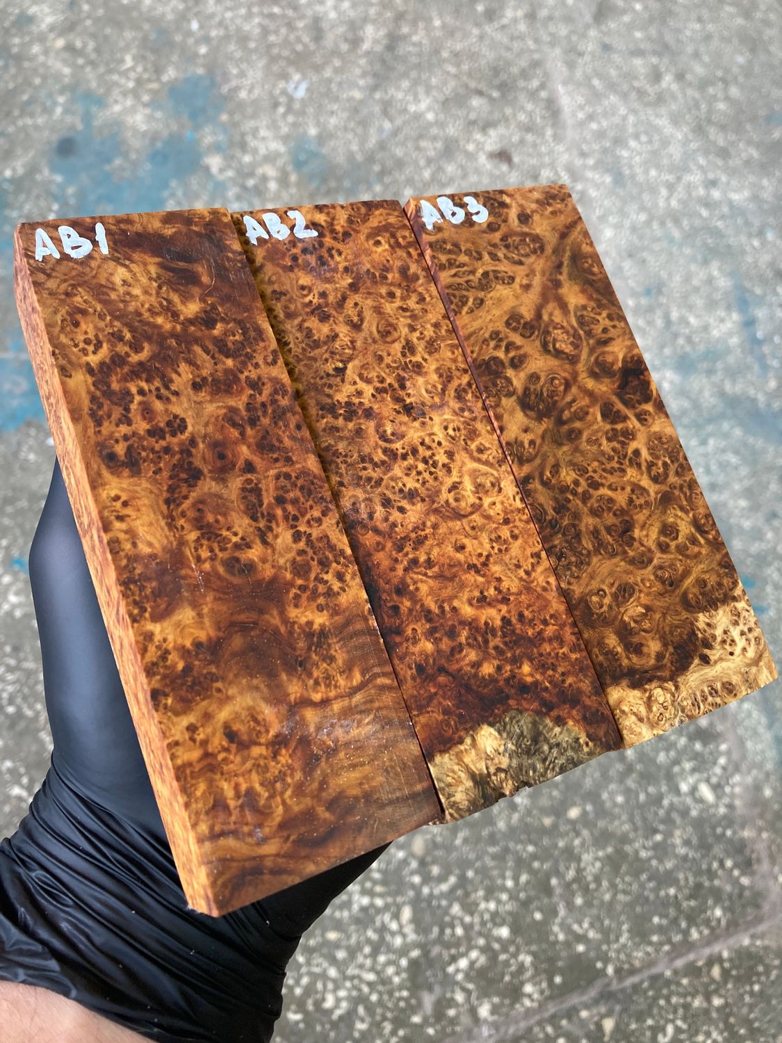 Amboyna burl wood blocks showing rich natural colors, dense burl figure, and distinctive swirling grain patterns.