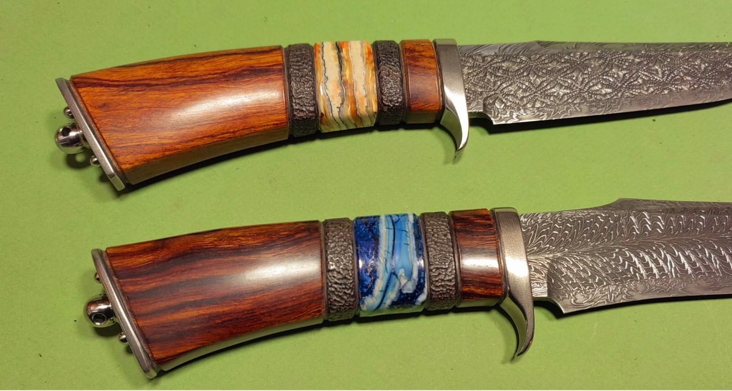 KTwo custom fixed-blade knives with Damascus blades and handles featuring stabilized mammoth tooth