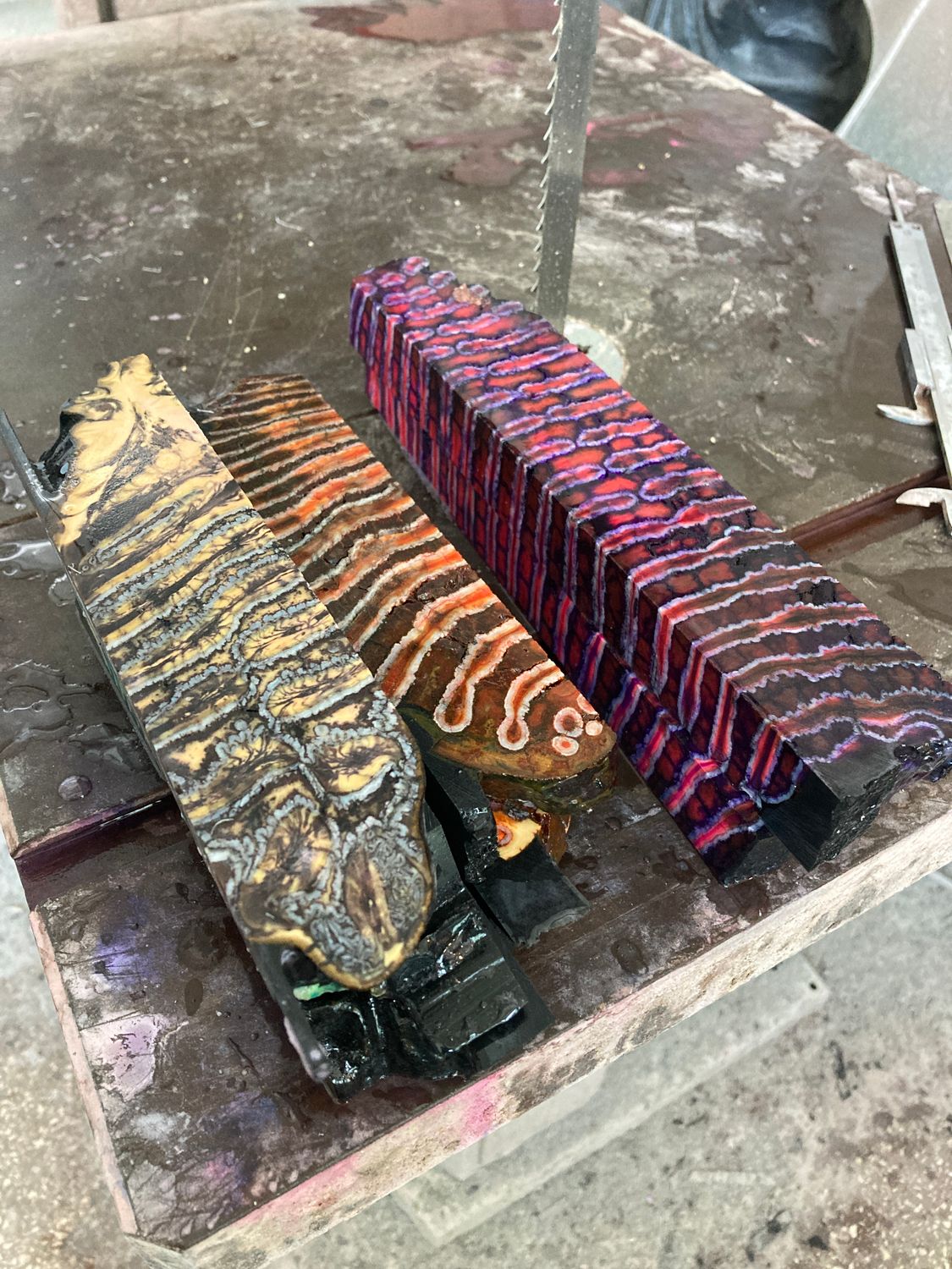 Freshly cut stabilized mammoth tooth pieces after processing on a water-cooled stone-cutting saw for custom knife handles.