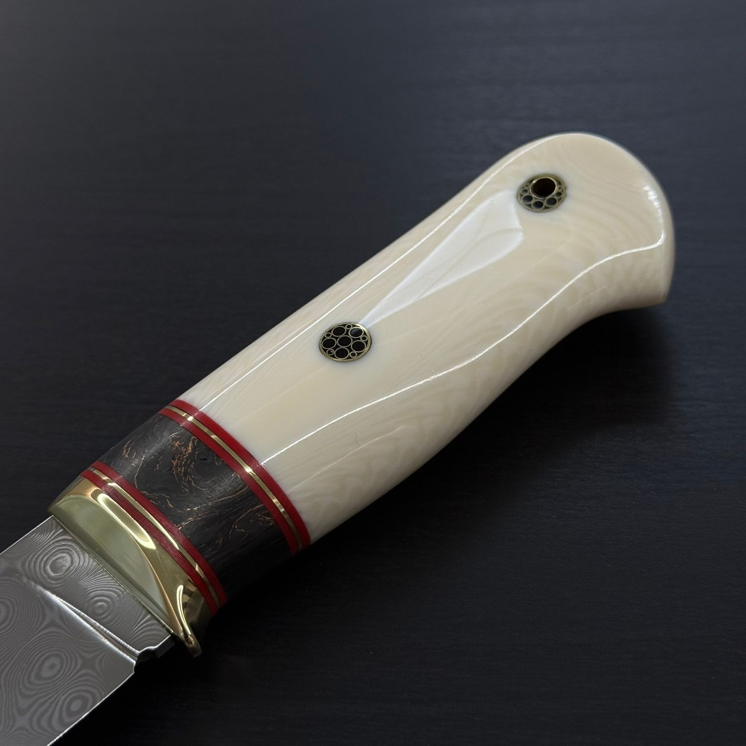 Custom knife featuring a handle made from Elforyn synthetic ivory, designed to replicate the appearance of natural elephant ivory.
