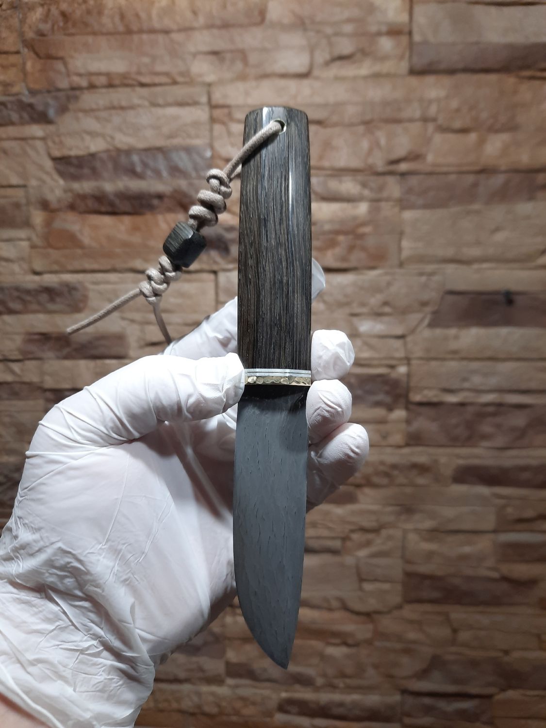 Custom knife with a handle made from stabilized bog oak, featuring rich dark grain and natural wood texture.