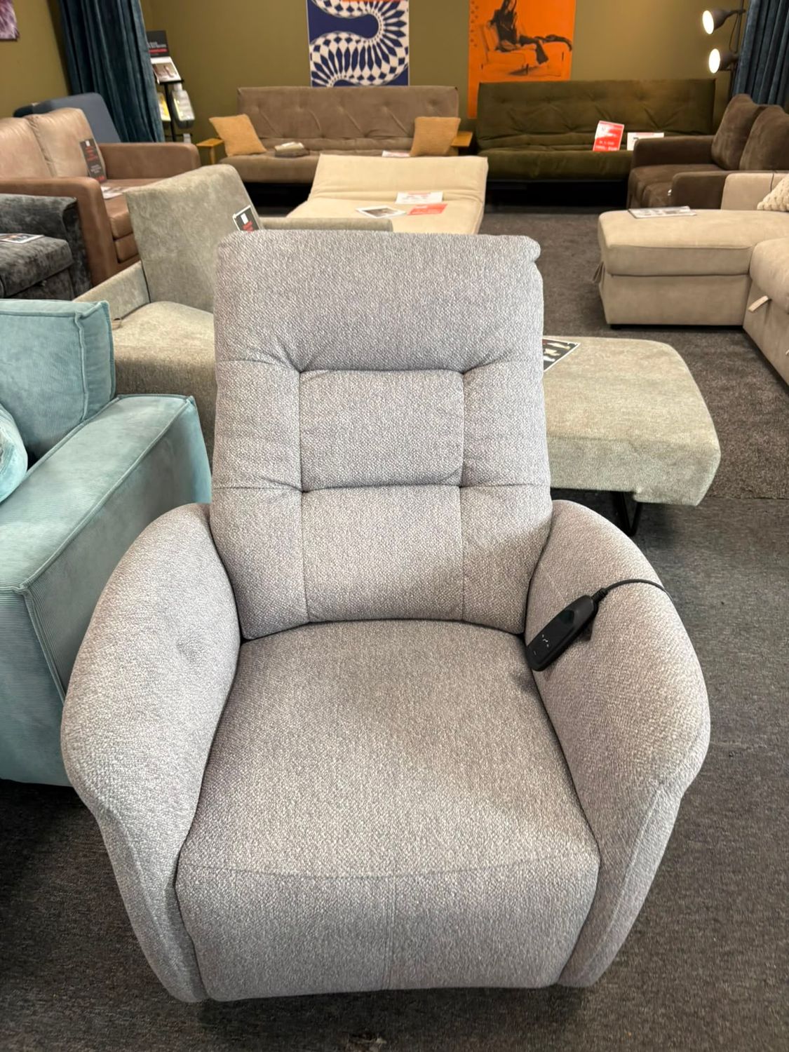 Irisa electric recliner chair in light grey with an adjustable reclining backrest and elevating footrest.