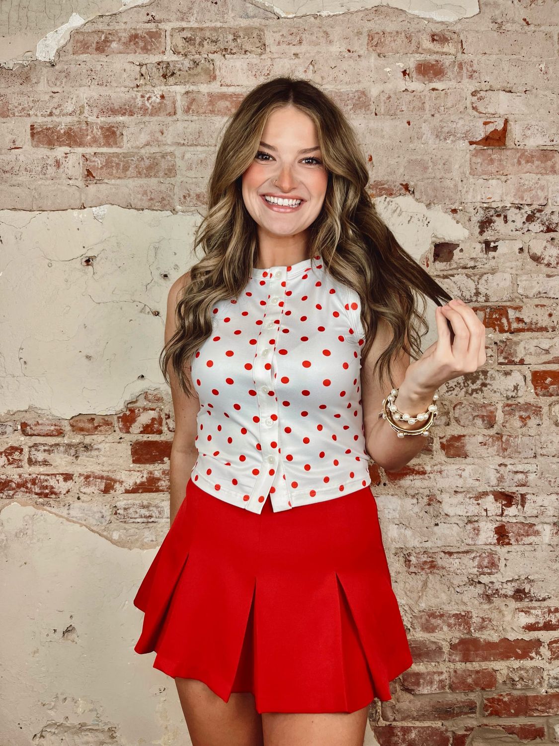 White sleeveless top with red polka dots and button front