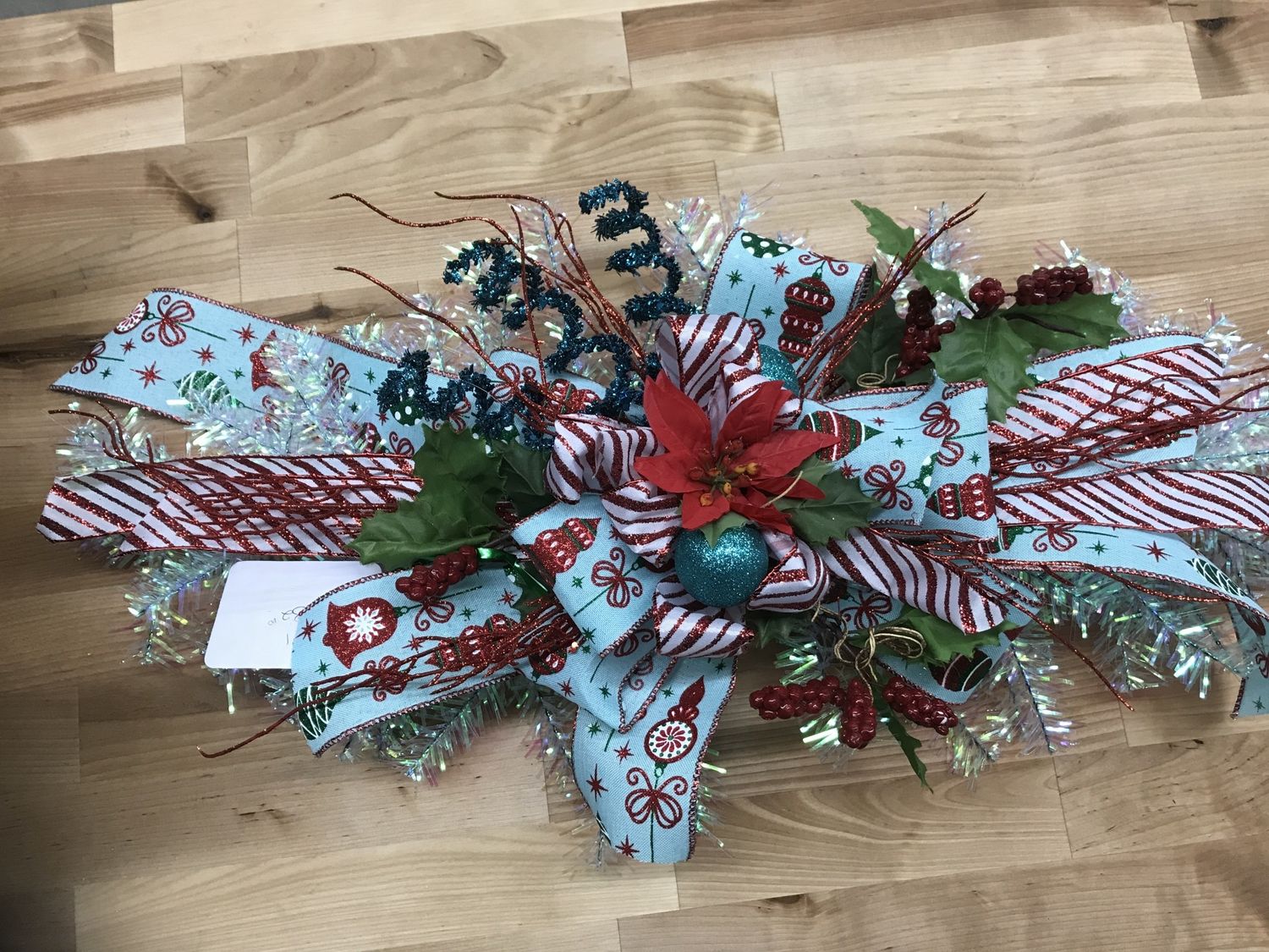 Swag Iridescent with Poinsettia and Blue Ornament and Red Striped Ribbon