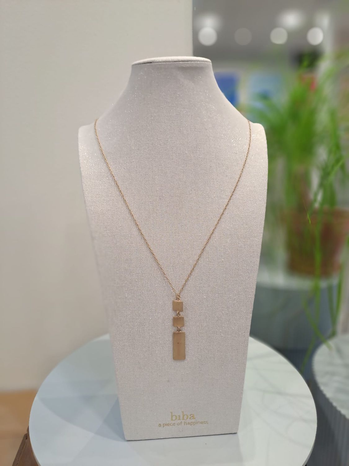 Lange ketting met gouden plaatjes