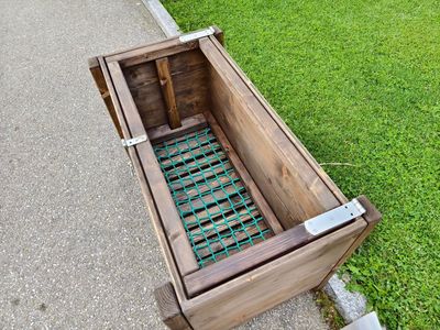 Original FUTTERKISTE CLASSIC LONG aus Holz mit grünem Gitterboden, braun, rechteckig, mit Metallscharnieren.