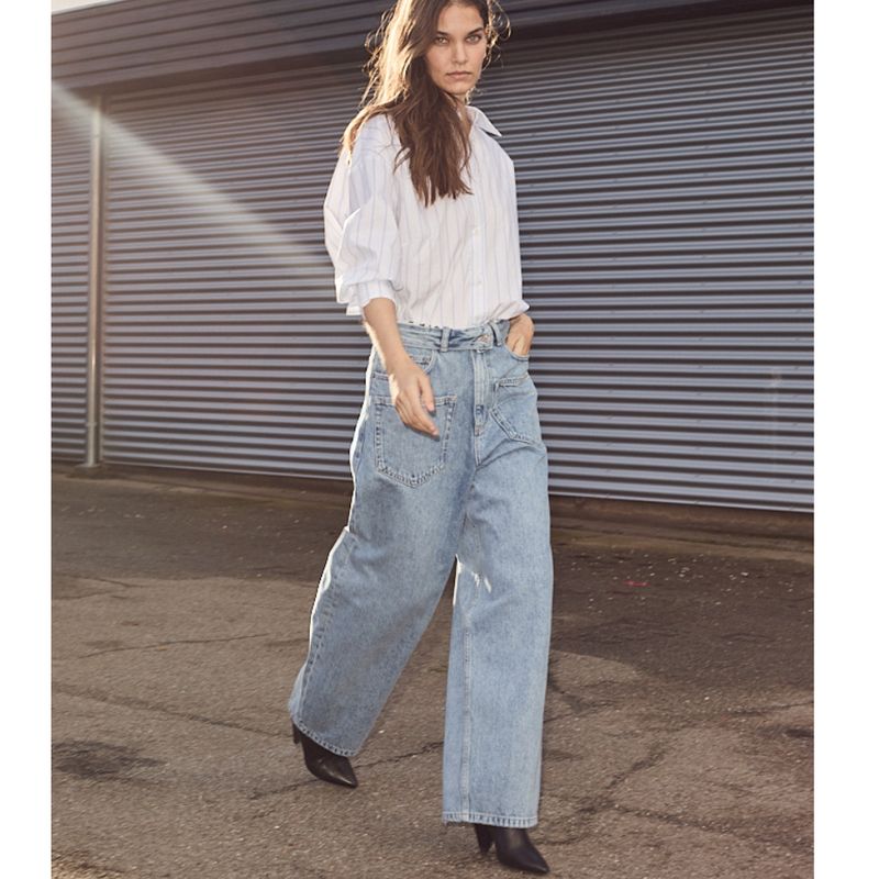 dame met witte blous en denim jeans