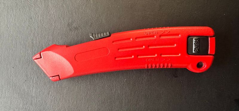 CUTTER SECURITE ROUGE METAL ROUGE  - LAME TRAPEZE AUTO RETRACTABLE