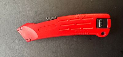 CUTTER SECURITE ROUGE METAL ROUGE  - LAME TRAPEZE AUTO RETRACTABLE