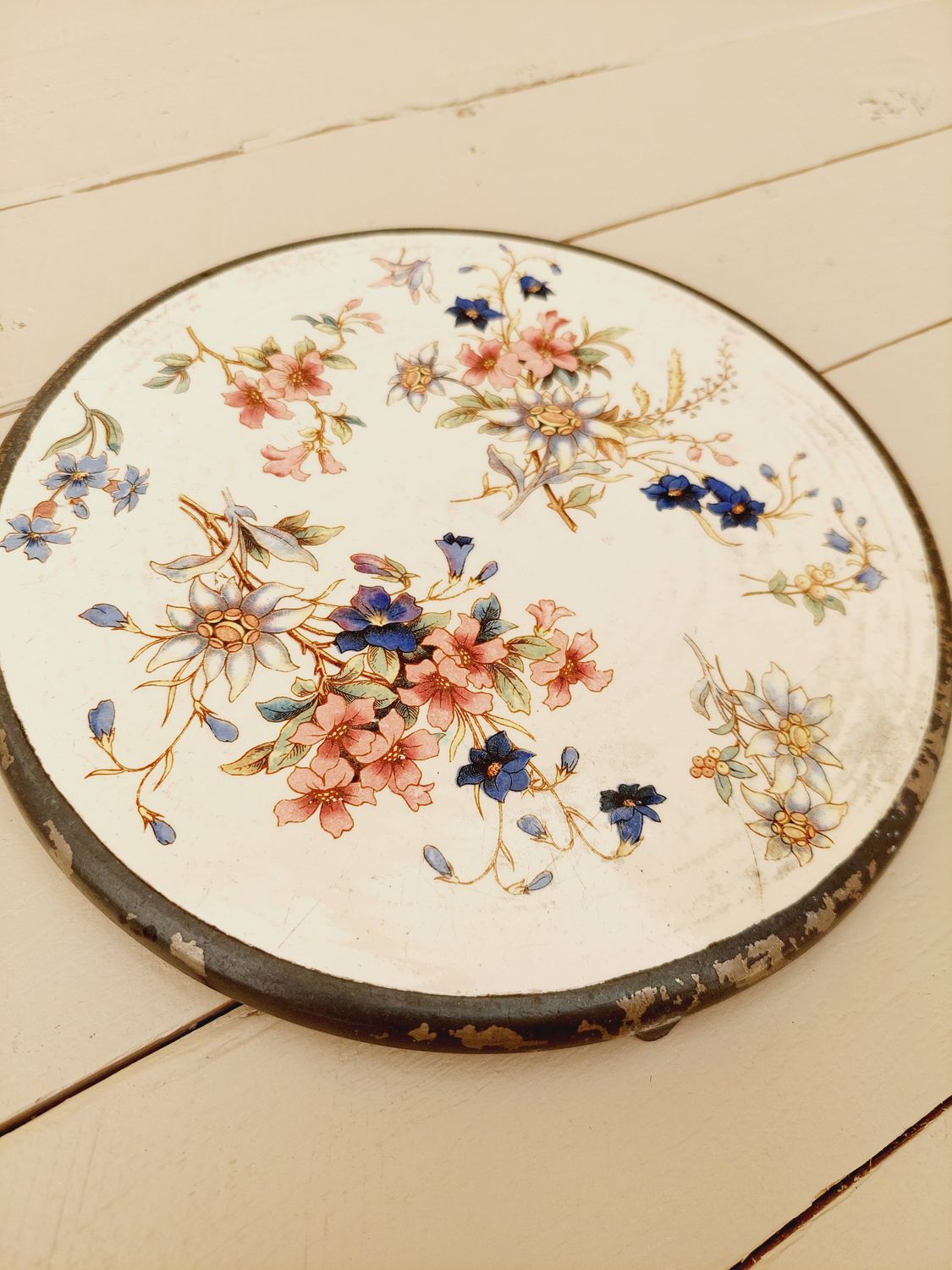 Antieke onderzetter met beige ondergrond, bloemen en verzilverde rand