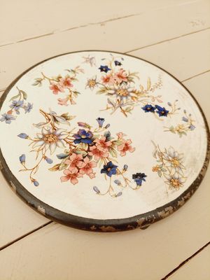 Antieke onderzetter met beige ondergrond, bloemen en verzilverde rand