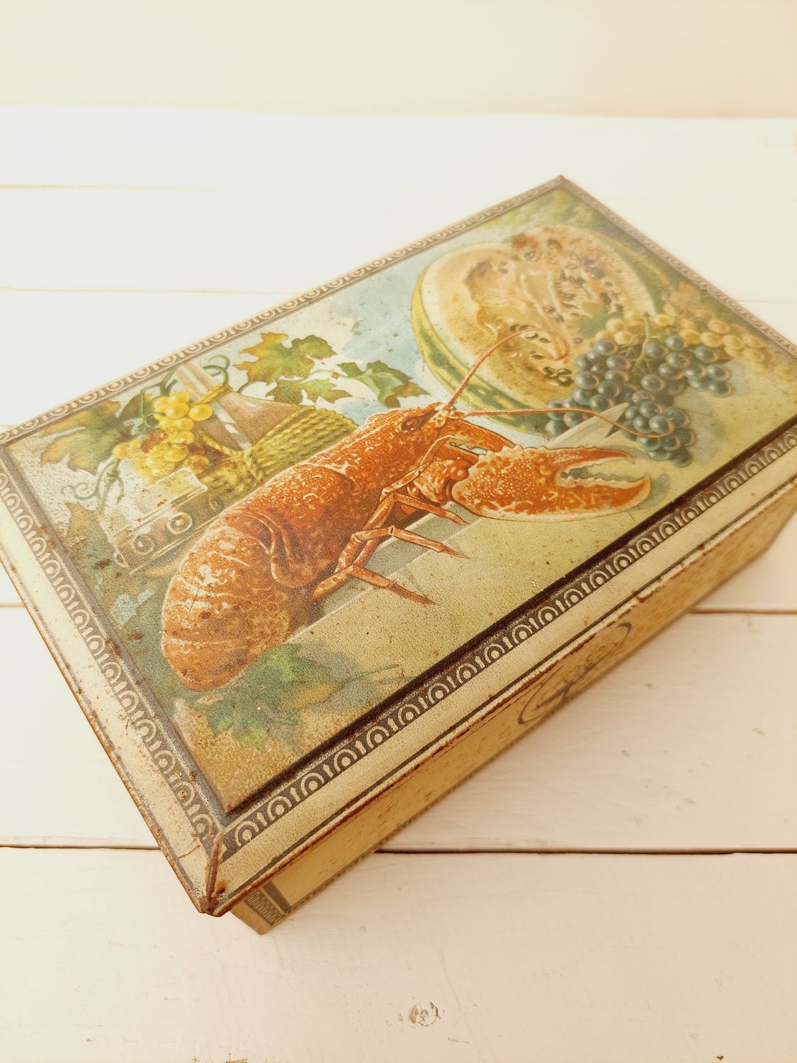Antiek blik met opdruk kreeft, meloen en druiven