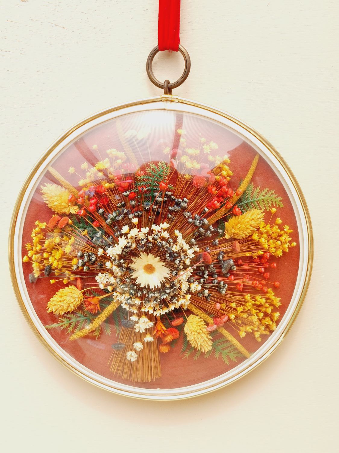 Vintage droogbloemenkader met bolglas en rood ophanglint – romantische muurdecoratie