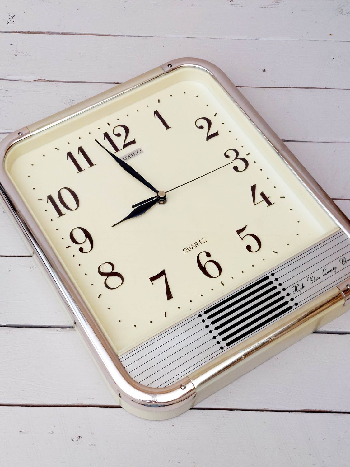 Vintage wandklok Adelco - Quartz klok - lichtgeel kunststof