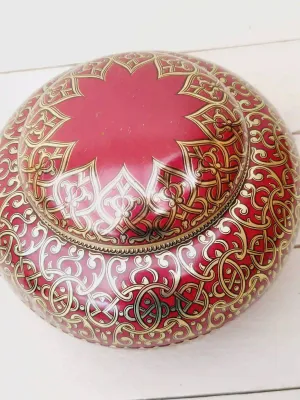 Vintage blik in Oosterse stijl, rond met rode basis en gouden sierlijke decoratie