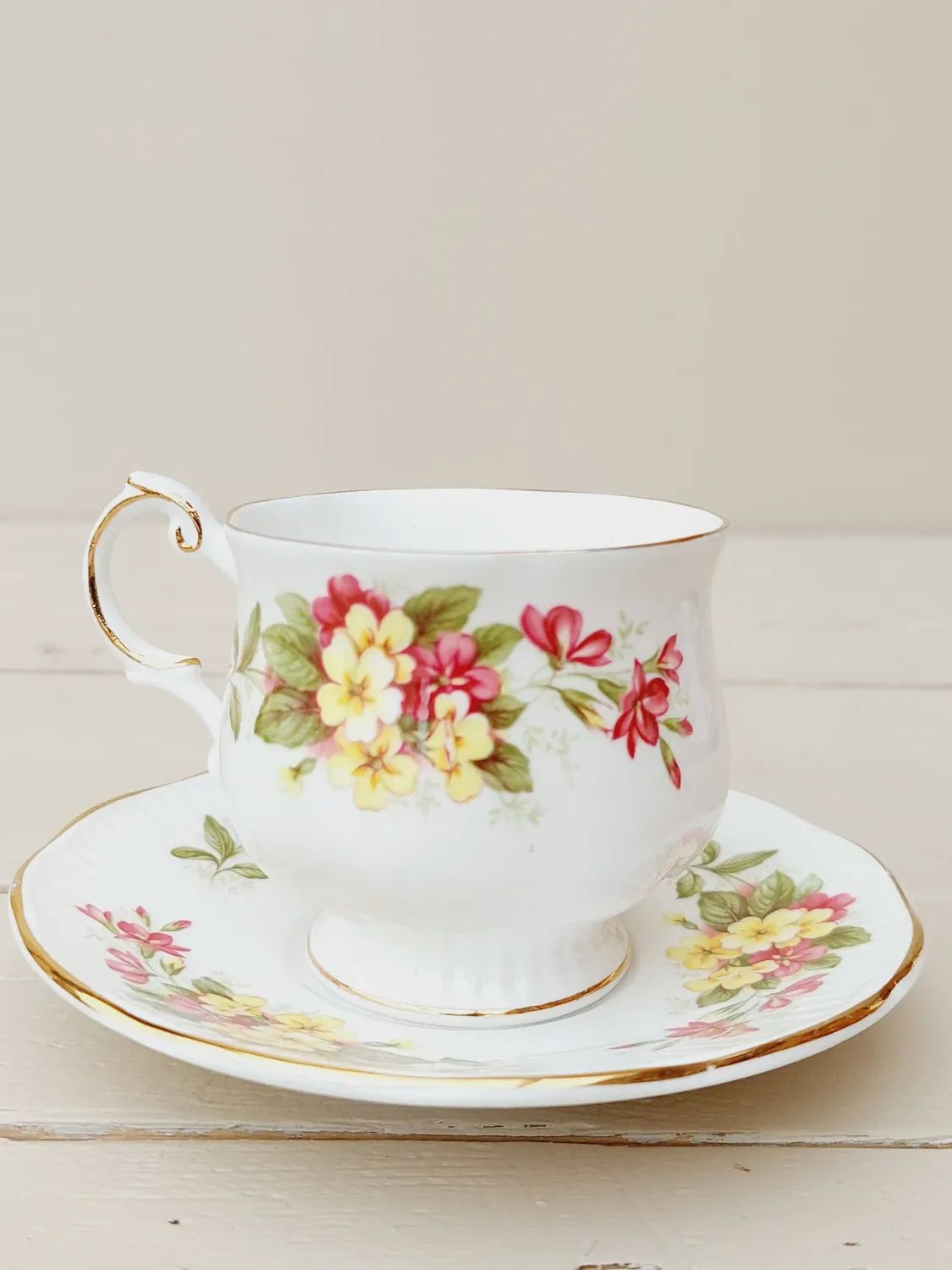 Kop met schotel Queens Wild Flowers, met gele en roze bloemen en goude rand