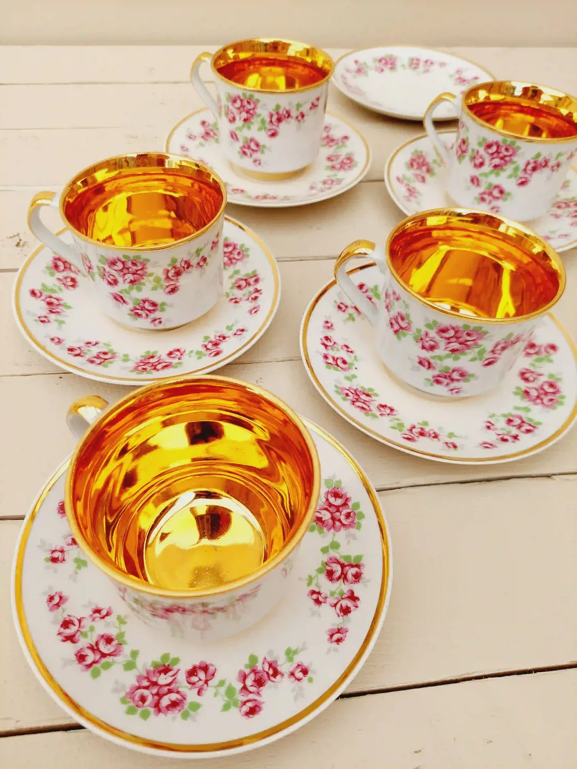 Kopjes met schotels, wit porselein met vergulde binnenkant en roze bloemetjes, set van 5