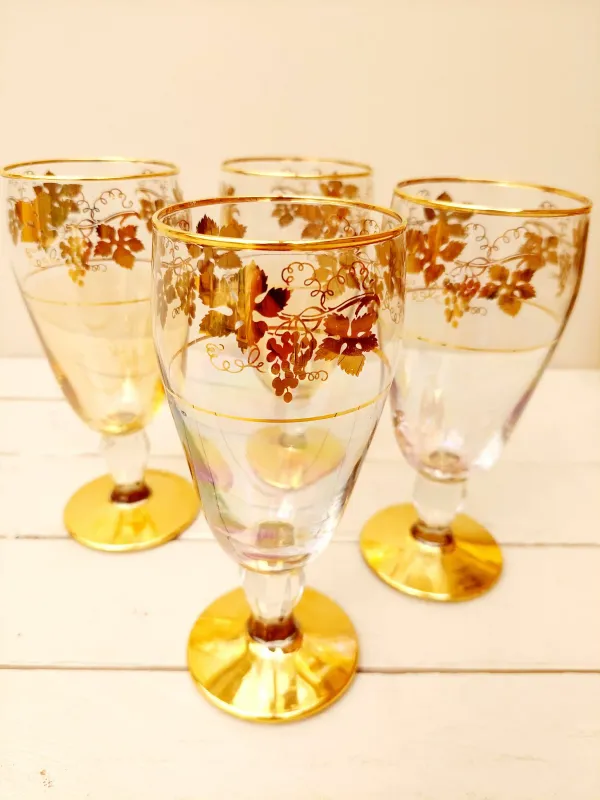 Set van vier vintage glazen met pastelkleuren en goudopdruk