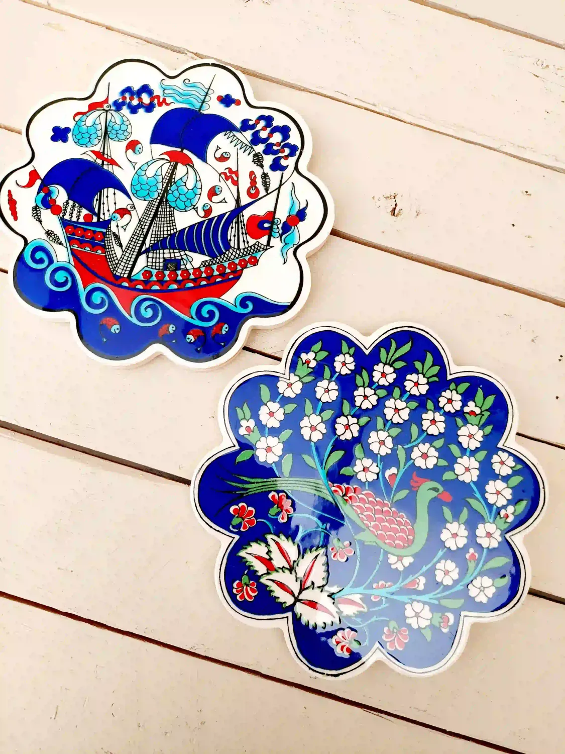 Set van twee vintage onderzetters met kleurrijk decor van vogels, bloemen en zeilboot