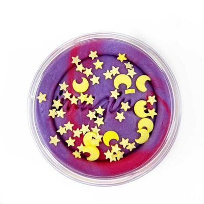 Bovenkant van een potje klei waarin boven op de rode/paarse klei gele sterren en maandjes liggen die gebruikt kunnen worden
