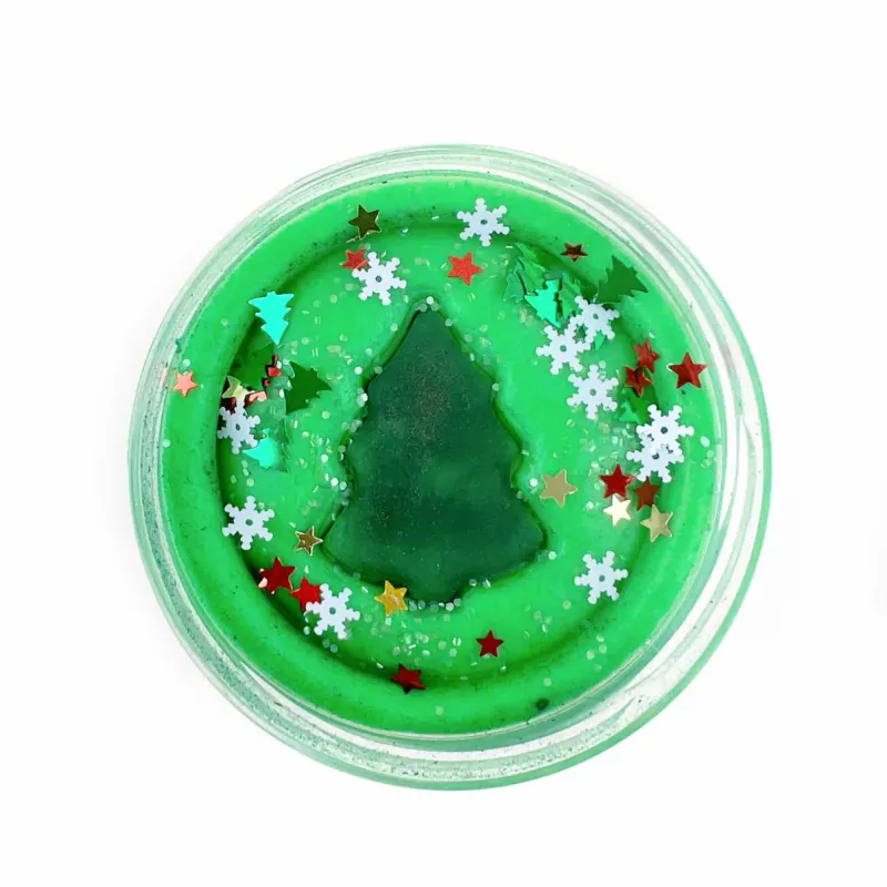 Groene speelklei met kerstboom vormpje in het midden en glitters in de toxic-vrij plastic bekertje.