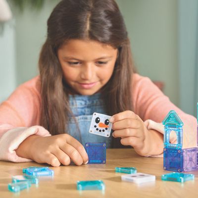 Kindje dat aan het spelen is met de travel set van magnetische stenen