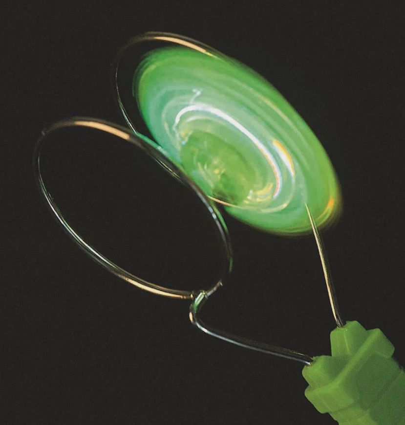 Tol die zweeft over een metalen rail, gestuurd door magnetische kracht en led verlicht in de kleur groen