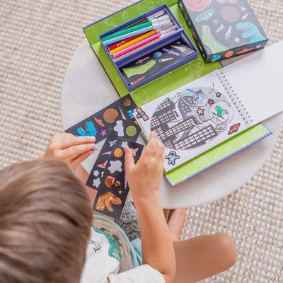 Kindje die de verpakking open heeft gemaakt en alle mooie stickers, stiften en kleurplaten bekijkt