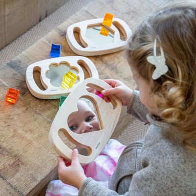 Kindje die aan het spelen is met de TickiT houten spiegel in 3 vormen sensorisch speelgoed.