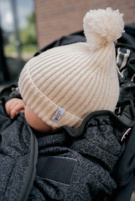 Kindje met de Lodger Merino wollen muts Birch – Newborn op zijn hoofd.