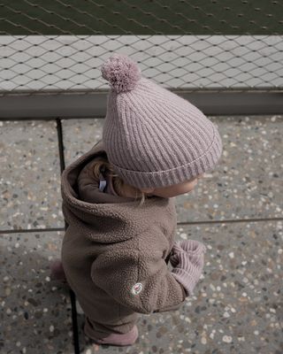 kindje met de Lodger Merino wollen muts Rose – Newborn op zijn hoofd.

