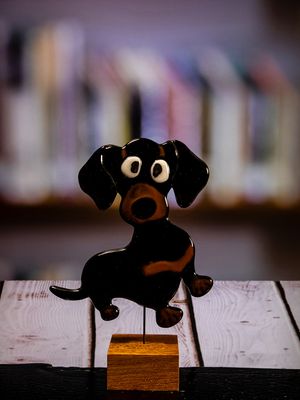Glasfigur Hund, gravhund, sort, brun, løber mod højre, på træfod
