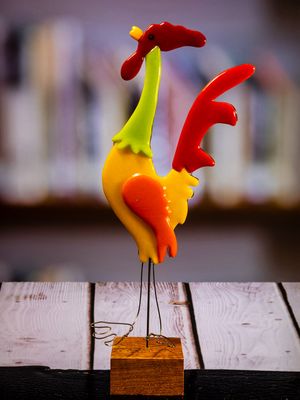 Glasfigur Hane, høj, gul, orange, grøn, rød, kigger mod vest, på træfod