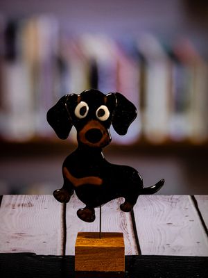Glasfigur Hund, gravhund, sort, brun, løber mod venstre, på træfod