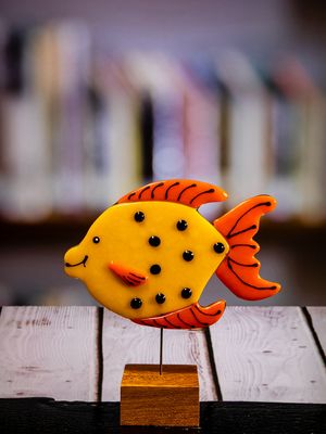 Glasfigur Fisk, gul, orange, med sorte pletter, på træfod