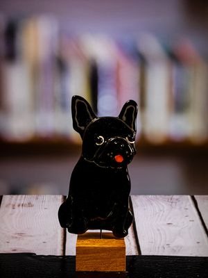 Glasfigur Hund, engelsk bulldog, kigger lidt mod højre, på træfod