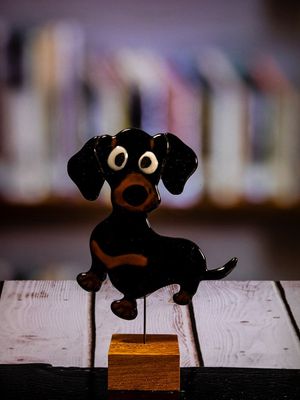 Glasfigur Hund, gravhund, sort, brun, løber mod venstre, på træfod