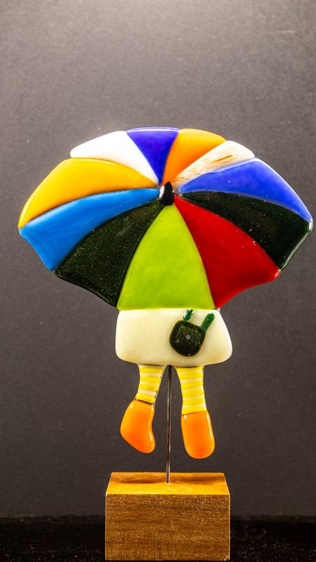 Glasfigur, Paraply pige, mange farvet paraply, lys nederdel, gule stribede strømper, orange sko