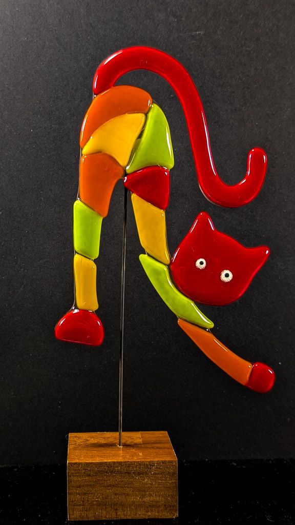 Glasfigur Kat, strækker sig, gul, rød, orange, grøn, med rødt hoved, på træfod