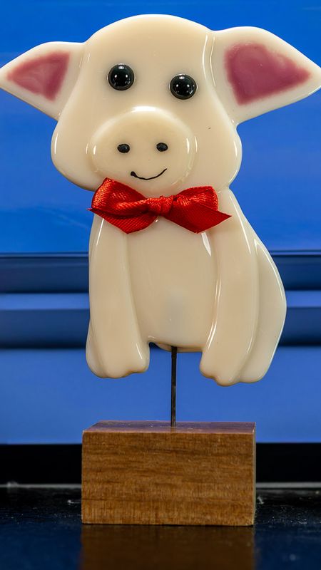 Glasfigur, siddende gris med butterfly, på træfod