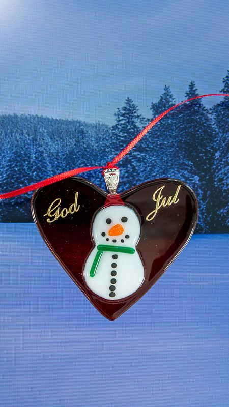 Glasfigur, juletræspynt, rødt hjerte i transparent glas, med snemand med grønt halstørklæde, til ophæng