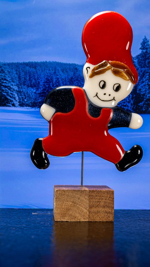 Glasfigur Nissedreng med grå bluse, løber mod højre, på træfod Glasfigur Nissedreng med grå bluse, løber mod højre, på træfod