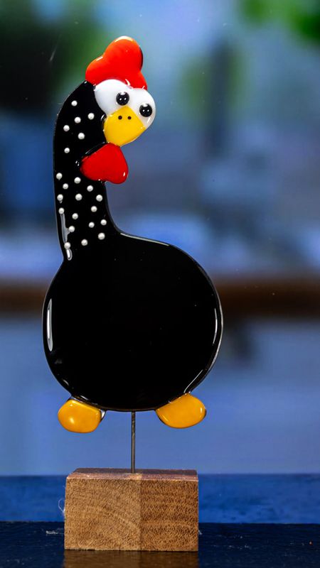 Glasfigur, høne, sort, hvide prikker, hoved mod højre, på træfod