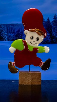 Glasfigur Nissedreng med grøn bluse, brunt hår, løber mod højre, på træfod Glasfigur Nissedreng med grøn bluse, brunt hår, løber mod højre, på træfod