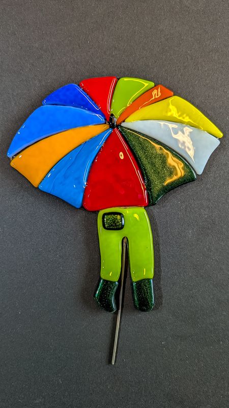 Glasfigur, Paraply dreng i mange farver med grønne bukser og grønne sko, på træfod