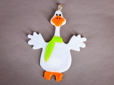 Hvid håndlavet glasgås med orange næb og limegrønt tørklæde.
