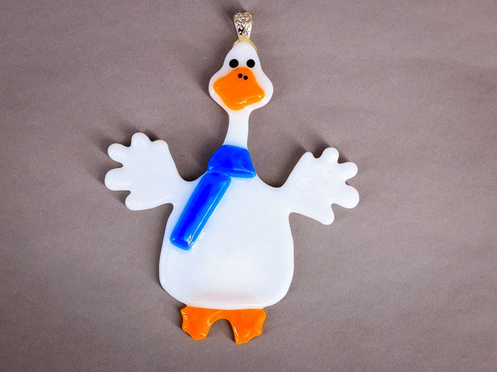 Hvid glasgås med orange næb og kraftigt kongeblåt tørklæde.